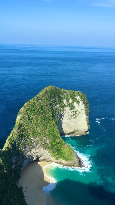 白天在蓝色海洋上形成绿色和棕色岩石